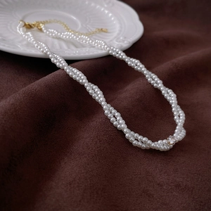 Detailed close-up of double-layer pearl choker with zircon accent and gold lobster clasp