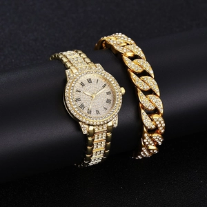 Close-up of sparkling gold watch and Cuban chain bracelet set with pavé rhinestones