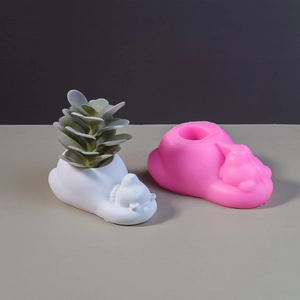 Macro view of pink silicone mold with finished white bear succulent planter and greenery