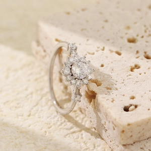Luxurious S925 silver flower ring with round zircon stones on a beige stone surface