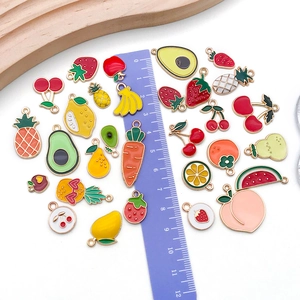Assorted enamel fruit charms for DIY jewelry with ruler showing size and scale