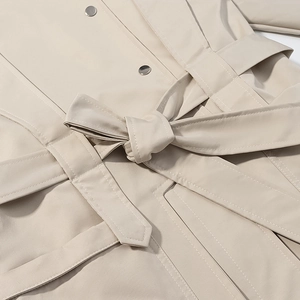 Detail of khaki windbreaker showing adjustable waist belt and silver metal buttons