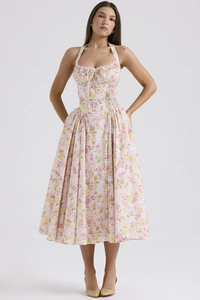 Detail of floral print pattern on a pink halter neck dress with ruffled pleated hemline