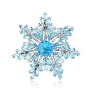 Elegant silver snowflake brooch featuring light blue cubic zirconia with detailed ice crystal design
