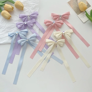 Set of pastel bow hair clips with heart-shaped rhinestones in purple, blue, and pink