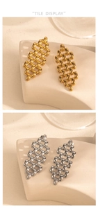 Macro detail of gold and silver chunky chain earrings on a beige stone surface