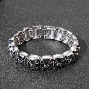 Punk style silver stainless steel bracelet featuring skull and cross embossed elements