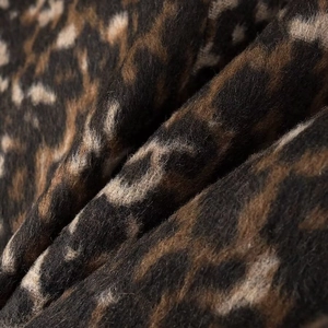Macro dettaglio della trama leopardata e del tessuto in misto lana spesso del cappotto