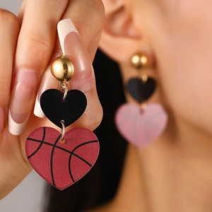 Détail de boucles d'oreilles en forme de cœur avec texture de basket-ball créative