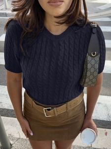 Détail du pull en maille bleu marine à manches courtes avec texture torsadée classique