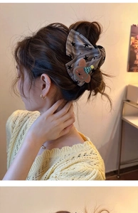 Detail of fabric bow hair claw clip with grey stripes and a cute brown bear ornament