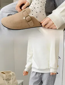 Detail of khaki suede mule with adjustable metal buckle and polka dot socks