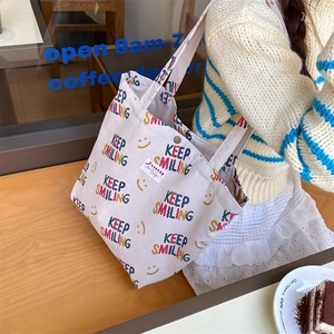 Detail of off-white corduroy tote bag with Keep Smiling embroidery and Zakka label