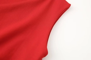 Detailed close-up of red ruched fabric texture and stitching on a mini dress