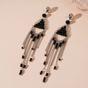 Détails macro des perles en verre noir et boucles d'oreilles à pampilles en argenté