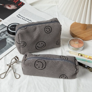 Detailed close-up of dark grey corduroy makeup bag set with iconic smile print