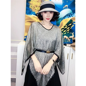 Details des eleganten silbergrauen Strickschals, getragen über einem schwarzen Kleid