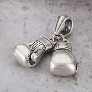 Retro silver boxing glove pendant in stainless steel on a textured grey background