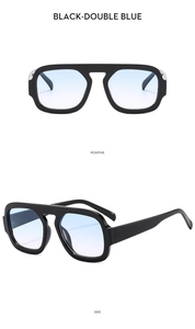 Detail view of black square oversized sunglasses with gradient blue lenses and thick frame