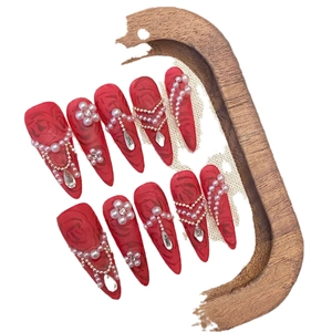 Unghie finte stiletto rosse fatte a mano con perle e raffinati motivi floreali di peonia.