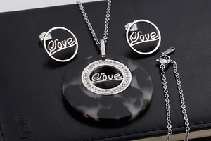 Detail of silver Love jewelry set with black patterned rings and small crystals