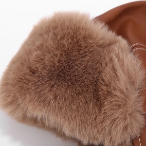 Detailed close-up of brown faux fur texture and leather stitching on a winter trapper hat