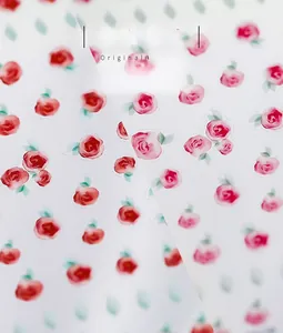 Macro detail of delicate watercolor rose nail stickers with pink and red floral patterns