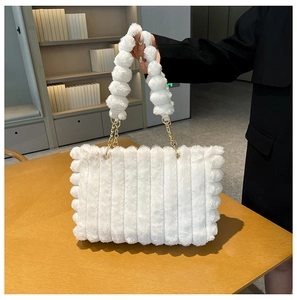 Detail of white plush tote bag with vertical texture and gold chain link handle