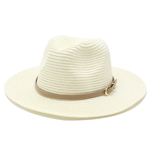 Dettaglio cappello di paglia con cinturino in pelle marrone e fibbia in metallo dorato