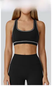 Detail of high-stretch black yoga bra and leggings set with white contrast stitching