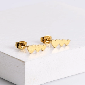 Three linked heart-shaped stud earrings in polished 18K gold finish on a minimal stand