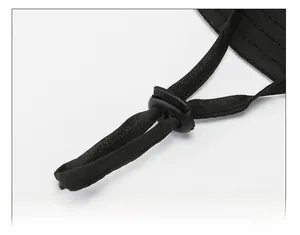 Detail of adjustable windproof chin strap with plastic toggle on a black outdoor sun hat