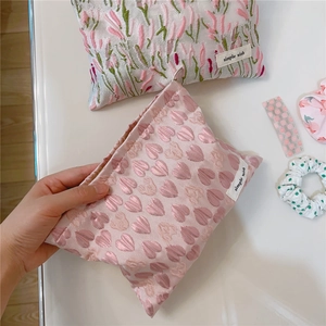 Detail of pink heart and floral jacquard pouches with woven label on white background