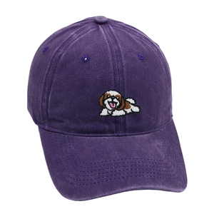 Close-up of the detailed white dog embroidery on a vintage purple cotton baseball cap