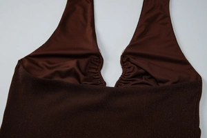 Detail of dark brown halter top showing the knit texture and pleated chest design