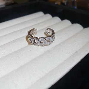 Detailed close-up of 18k gold-plated open ring with zircon coins on jewelry tray