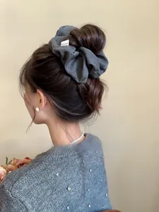 Detail of grey polka dot hair scrunchie with Hand Made label on model ponytail