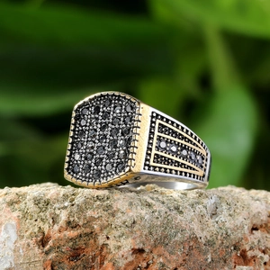 Makro-Detail des Herrenrings aus Titanstahl mit Drachenkrallen und schwarzen Edelsteinen
