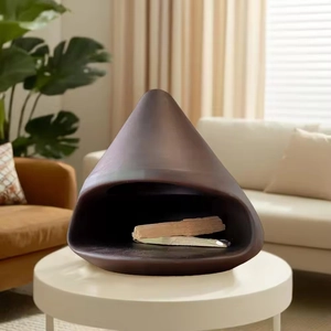 Deep brown ceramic Palo Santo holder with wood sticks on a modern white living room table