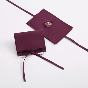 Macro detail of wine red suede jewelry pouch with ribbon tie closure design