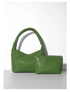 Vista dettagliata della borsa intrecciata verde erba e pochette in pelle liscia