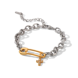Detailed view of two-tone stainless steel bracelet with golden safety pin and cross charm