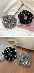 Close-up of sparkling sequin polka dot scrunchies in elegant black and silver colors