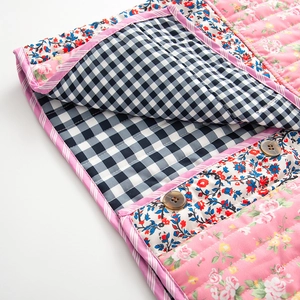 Vue détaillée d'une veste réversible matelassée avec fleurs et motifs à carreaux