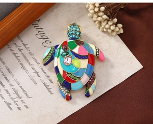 Macro detail of vintage gold turtle brooch with colorful enamel mosaic and sparkling crystals