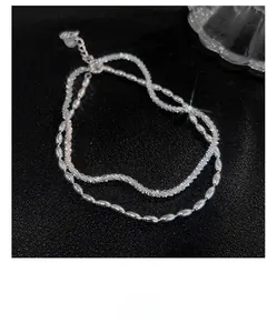Detail of silver double-layered bracelet with smooth rice beads and rope chain texture