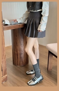 Classic collegiate style dark grey pleated skirt paired with silver Mary Jane shoes
