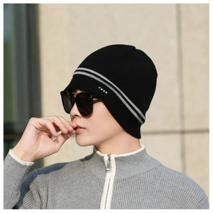 Detail of winter knit beanie with stripe pattern and brand label on a model