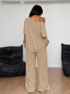 Rear view of women's loose light khaki two-piece set featuring off-shoulder top and wide-leg pants
