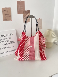 Détail du sac cabas en toile à pois rouge et blanc avec anses tissées et étiquette tissu